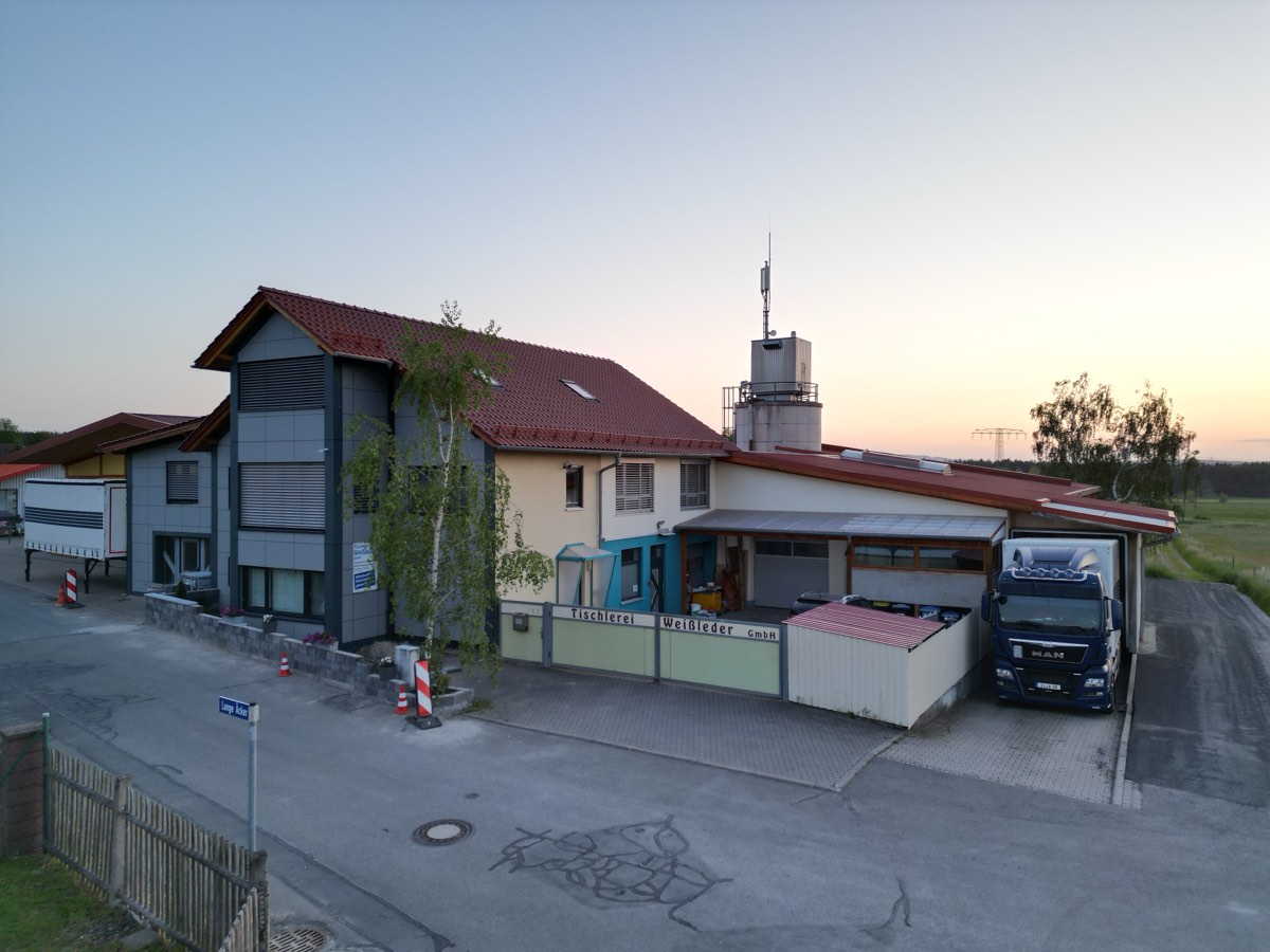 Luftaufnahme der Tischlerei Weißleder in Pennewitz in der Abenddämmerung